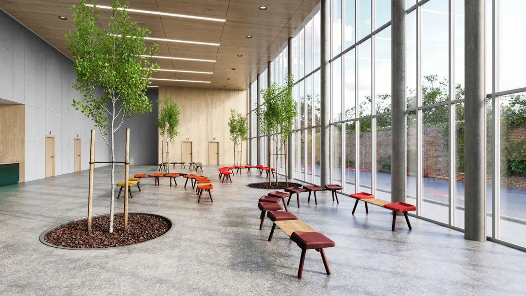 Hall amplio con bancos Slim en tonos rojos junto a un ventanal y árboles interiores