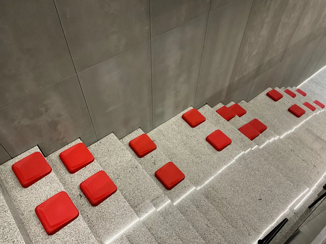 Escalera de piedra con cojines Slim rojos repartidos en los peldaños