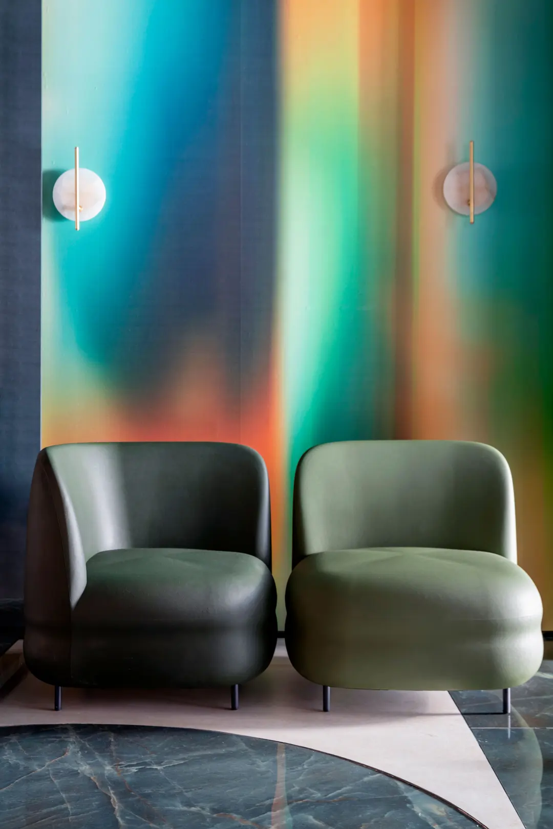 Dos sillones Vistas verdes frente a un mural de colores